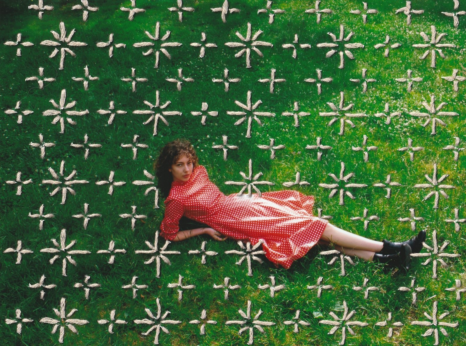 Portrait of a young woman lying in a meadow, with colourful embroidery stitched directly onto the photograph, a mixed media piece combining photography and textile art. Leila by Katarina Eva, Woman Portrait Gallery.